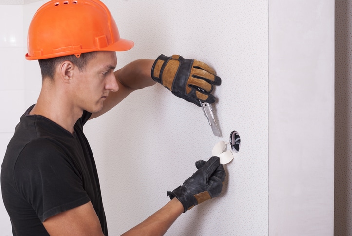 Electrician installs lighting switch